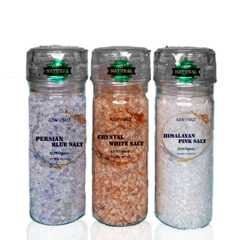 3 types of mineral salt (blue, white, pink) with small salt mills